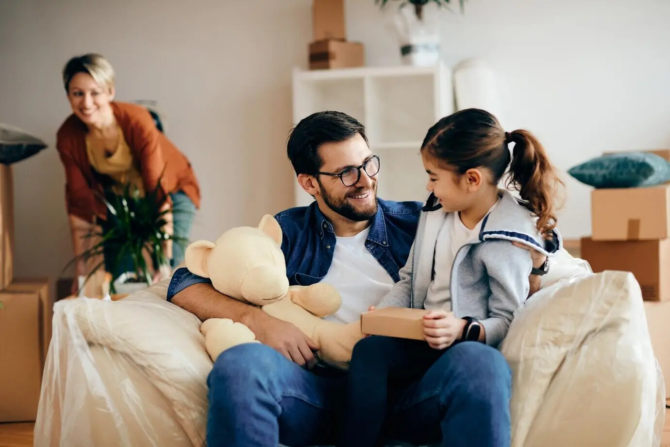 Un père et sa fille, heureux, discutent pendant qu’ils emménagent dans une nouvelle maison.